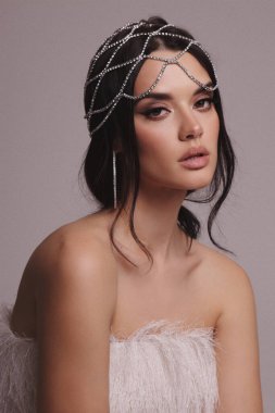 Güzel, siyah saçlı, takı ve saç aksesuarlarıyla süslü güzel bir Slav kadının moda fotoğrafı.