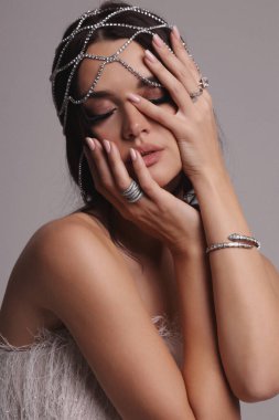 Güzel, siyah saçlı, takı ve saç aksesuarlarıyla süslü güzel bir Slav kadının moda fotoğrafı.