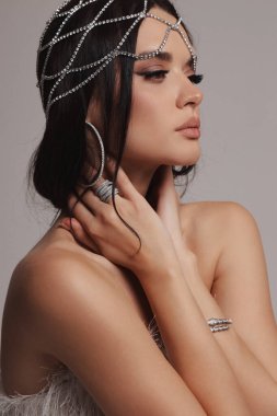 Güzel, siyah saçlı, takı ve saç aksesuarlarıyla süslü güzel bir Slav kadının moda fotoğrafı.