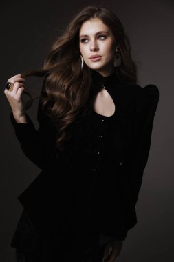 Slav bir kadının güzel, siyah saçlı, lüks elbiseli ve stüdyoda poz veren aksesuarlı bir fotoğrafı.