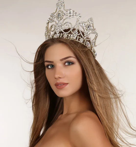 Beautiful girl with long hair wears luxurious dress and crown — Zdjęcie stockowe