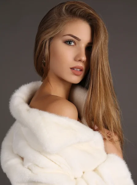 Beautiful  woman with long hair wears luxurious white fur coat — Stok fotoğraf