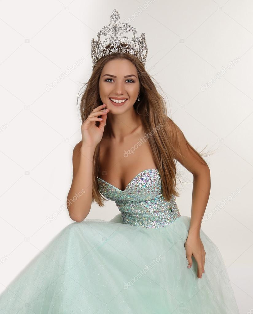 beautiful girl with long hair wears luxurious dress and crown