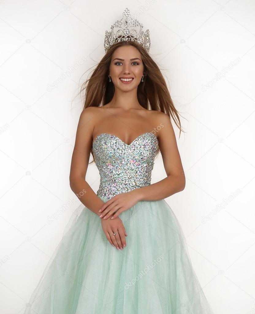 beautiful girl with long hair wears luxurious dress and crown