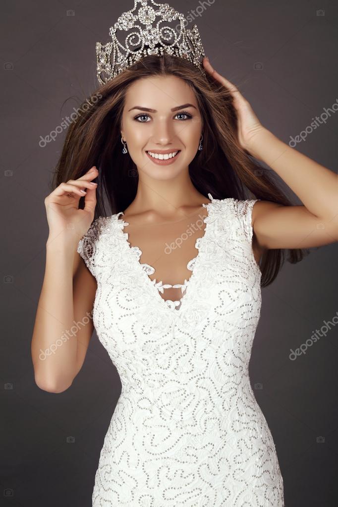 beautiful girl with long hair wears luxurious dress and crown
