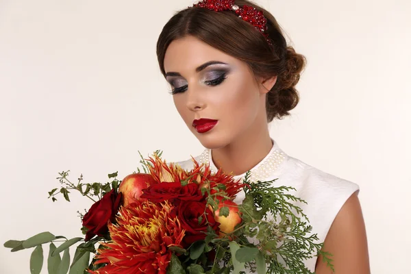 Bella giovane donna con i capelli scuri e trucco luminoso con mazzo di fiori — Foto Stock