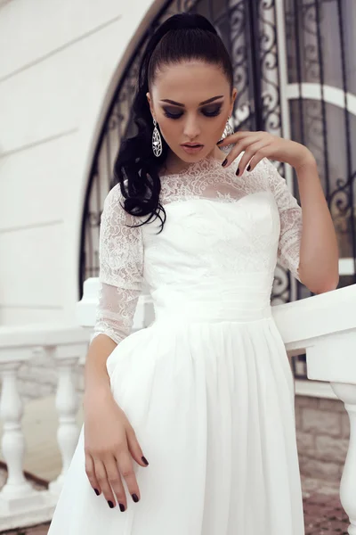 Молодая женщина с длинными темными волосами в роскошном кружевном свадебном платье — стоковое фото