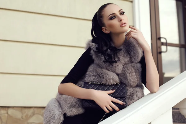 Gorgeous woman with long dark hair wears luxurious fur coat — Stock Photo, Image