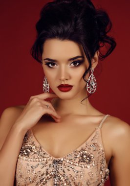 gorgeous woman with dark hair wears luxurious sequin dress and bijou