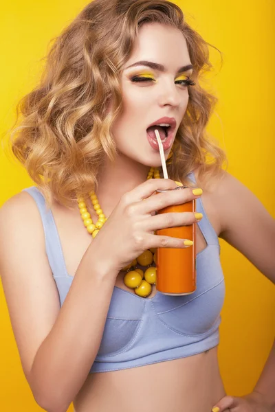 Mädchen mit blonden lockigen Haaren mit Bijou, in der Hand eine orangefarbene Flasche Getränk — Stockfoto