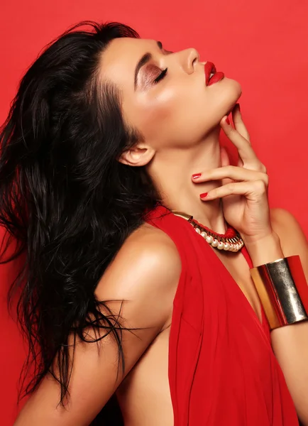 Sensual woman with dark hair wears elegant red dress and accessories — Stock Photo, Image