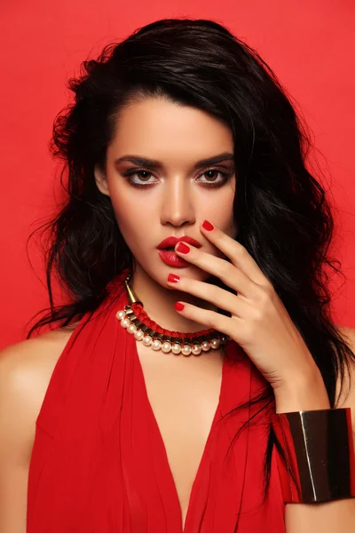 Sensual woman with dark hair wears elegant red dress and accessories — ストック写真