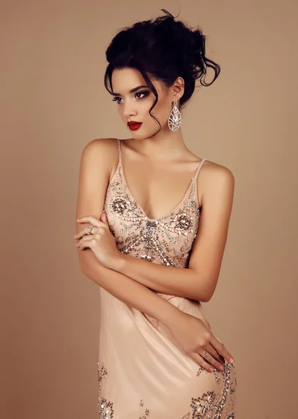 Gorgeous young woman with dark hair in luxurious dress — Stock Photo, Image