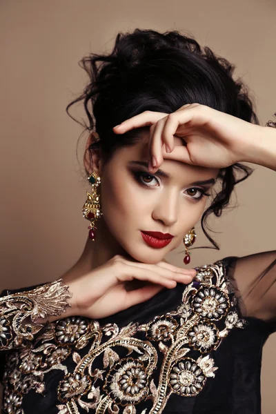 Gorgeous young woman with dark hair in luxurious dress — Stock Photo, Image