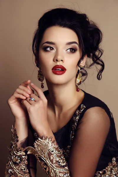 Gorgeous young woman with dark hair in luxurious dress — Stock Photo, Image