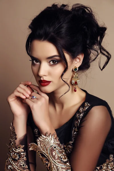 Gorgeous young woman with dark hair in luxurious dress — Stock Photo, Image