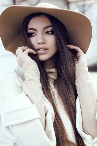 Chica glamour con pelo liso oscuro lleva lujoso abrigo beige con sombrero elegante — Foto de Stock