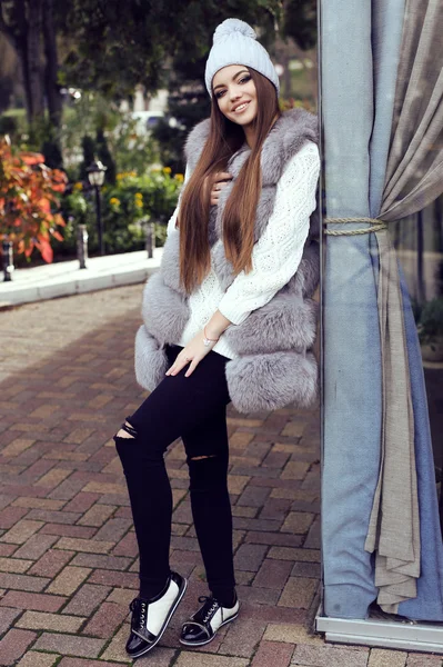 Menina glamour com cabelo liso escuro usa casaco de pele luxuoso e chapéu de malha — Fotografia de Stock