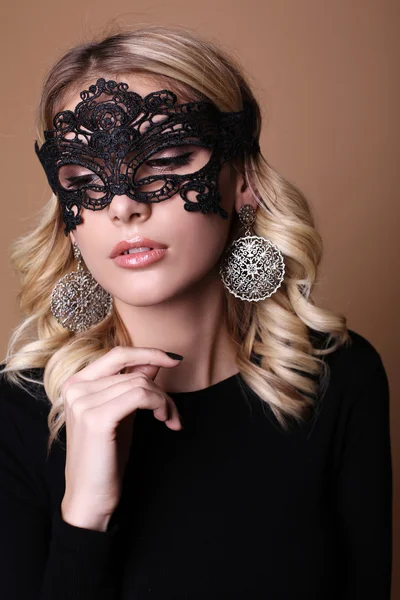 Mulher bonita com cabelo encaracolado loiro e maquiagem à noite, com máscara de renda no rosto — Fotografia de Stock