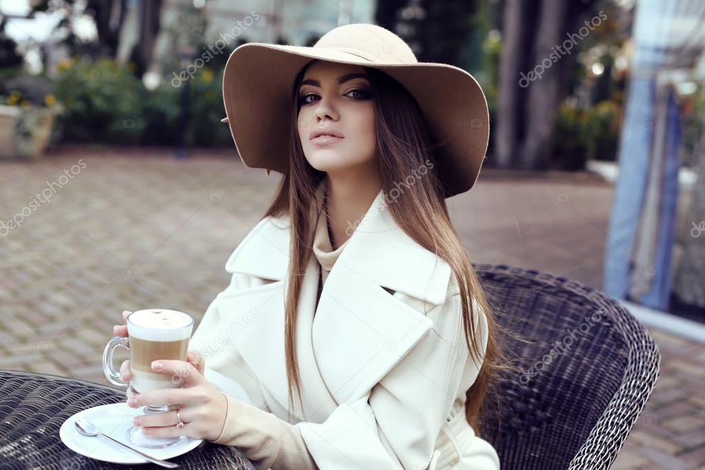 glamour girl  wears luxurious beige coat with elegant hat 
