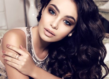 beautiful woman with dark curly hair and evening makeup 