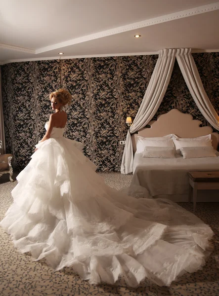 Gorgeous woman with blond hair wears luxurious wedding dress and bijou — Stock Photo, Image