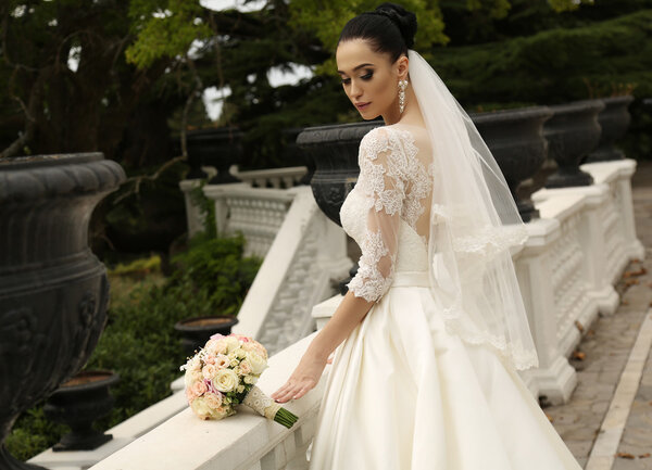 gorgeous bride with dark hair wears elegant wedding dress 