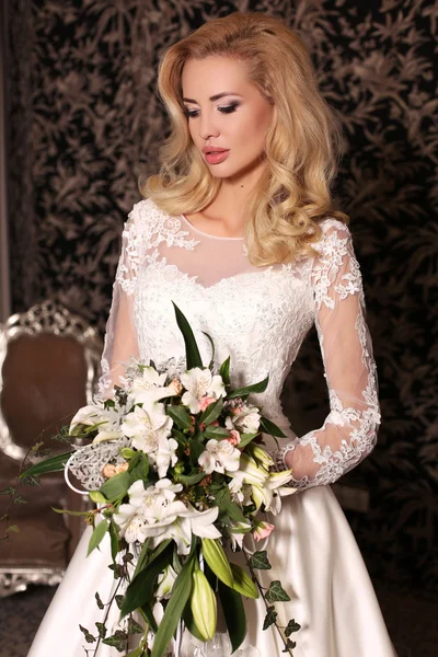 Gyönyörű nő, a szőke hajat visel luxus esküvői ruha, virág — Stock Fotó