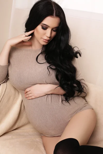 Έγκυος γυναίκα με μακριά σκούρα μαλλιά φοράει κομψή ζακέτα — Φωτογραφία Αρχείου