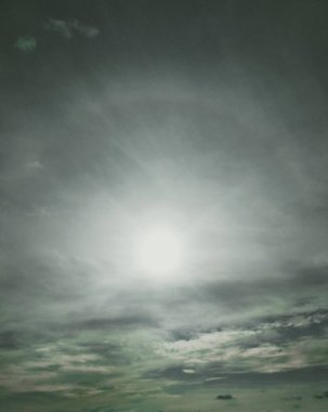 Etrafında haleler olan parlak bir güneş. 