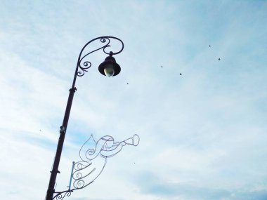 Mavi bulutlu gökyüzünün arka planına karşı bir sokak lambası, mimari karar 
