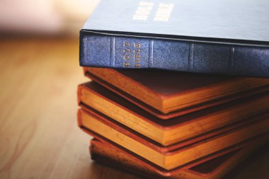  Üzerinde mavi bir İncil 'in omurgasına yakın çekim odaklı klasik İncil yığını. Dini çalışmaları, Hristiyan inancını, kutsal kitabı ve ruhani geleneği temsil eder..