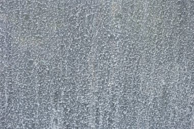 Su lekeleri ve mineral kalıntısı olan cam yüzeyin yakın çekimi. Şeffaf doku nem, yoğunlaşma ve kirli yüzeyi gösteriyor..