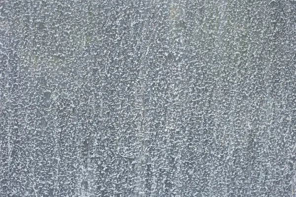 Su lekeleri ve mineral kalıntısı olan cam yüzeyin yakın çekimi. Şeffaf doku nem, yoğunlaşma ve kirli yüzeyi gösteriyor..