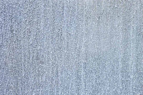 Su lekeleri ve mineral kalıntısı olan cam yüzeyin yakın çekimi. Şeffaf doku nem, yoğunlaşma ve kirli yüzeyi gösteriyor..