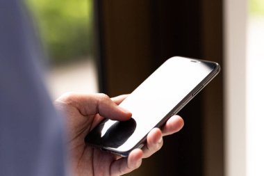 Teknoloji, iletişim ve mobil yaşam tarzı kavramları için uygun, boş ekran ile modern akıllı telefonu tutan insan elinin yakın çekimi.
