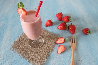 Çilekli milkshake mavi ahşap blackground üzerinde