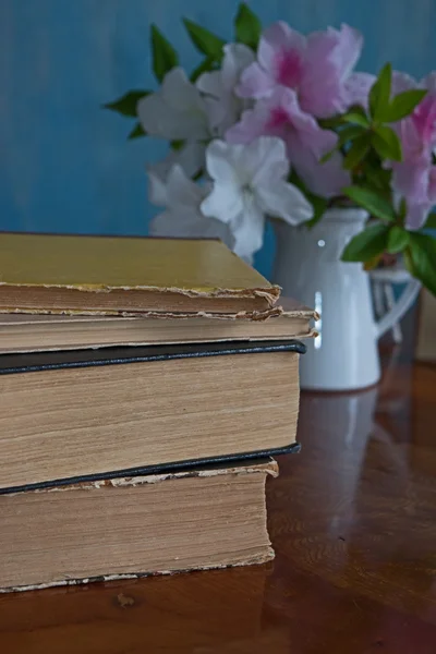 La pila de los libros sobre la mesa de madera, el hibisco —  Fotos de Stock