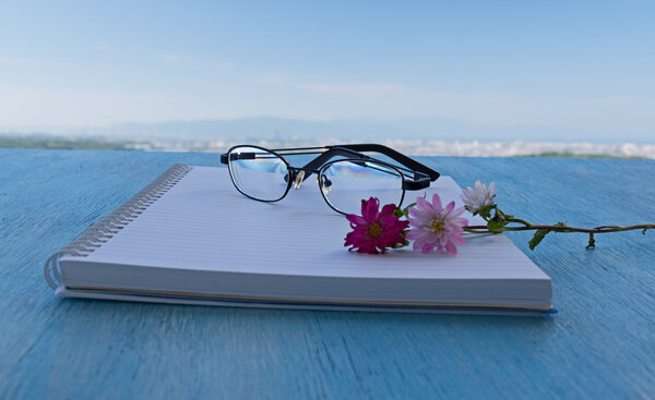 Glasses with notepad background beautiful sky