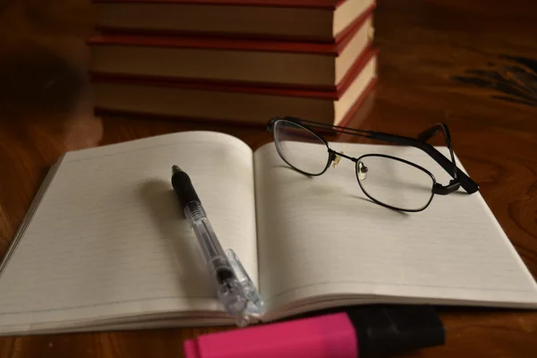 Cuaderno con bolígrafo y gafas, desarrollar memoria —  Fotos de Stock