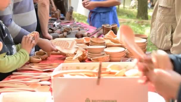 People looking at wooden dishware on trade fair — Stock Video