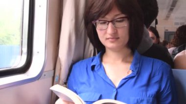 Genç kadın trende bir kitap okuma