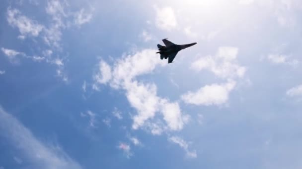 Истребитель летит босиком по синему солнечному небу — стоковое видео