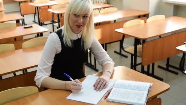 Jovem estudante tomando notas do livro em sala de aula — Vídeo de Stock