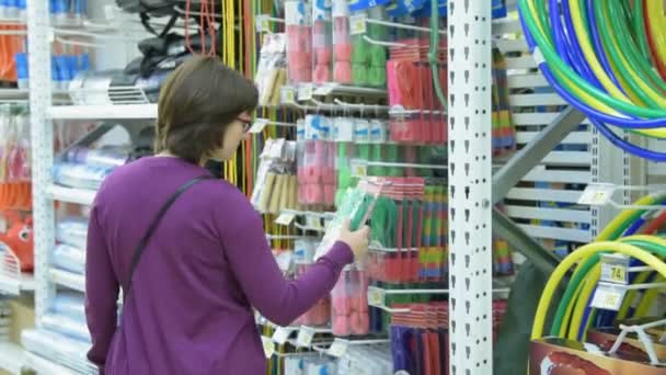 Mujer eligiendo saltar la cuerda en la tienda — Vídeo de stock