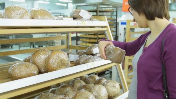 Mujer eligiendo pan en la tienda — Vídeos de Stock