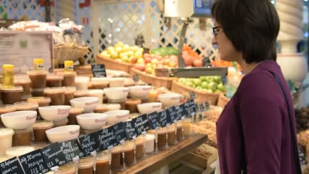 Mujer mirando contador con miel — Vídeos de Stock