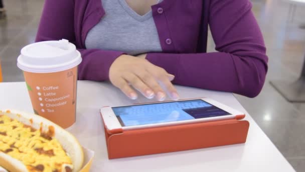 Woman typing email on touch pad in fast food cafe — Stock Video