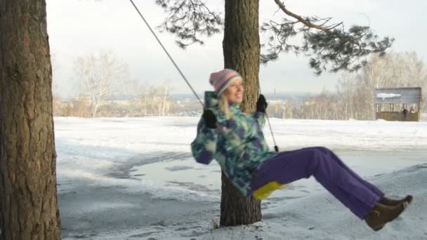 Dívka šla na houpačky mimo město v zimě — Stock video