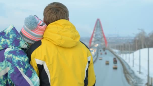 Verliefde paar kijken naar brug van de stad in de avond — Stockvideo